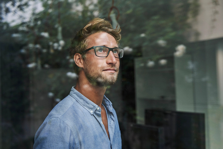 man staring out window