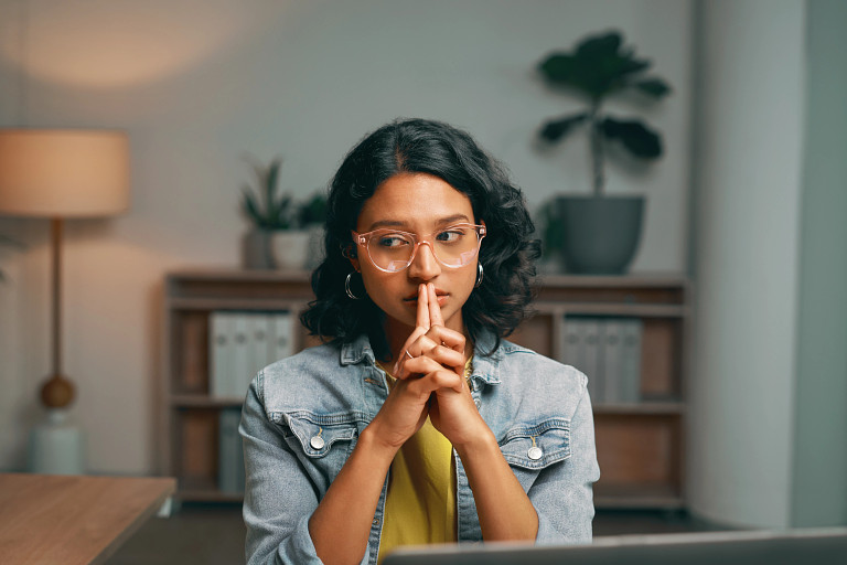 a person sitting at their desk looking thoughtful and concerned